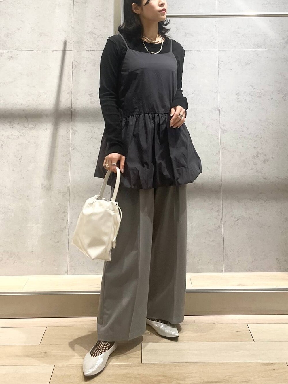 シルバー系のパンプス、ホワイト系のショルダーバッグ、グレー系のその他パンツを着用したレディースの春コーディネートの2枚目の写真