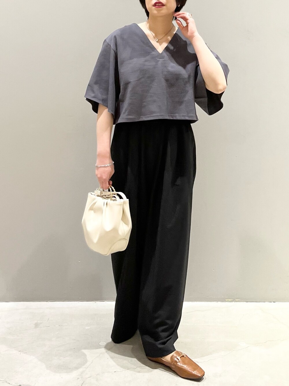 グレー系のTシャツ/カットソー、ブラック系のその他パンツ、ホワイト系のバッグを着用したレディースの春コーディネートの2枚目の写真