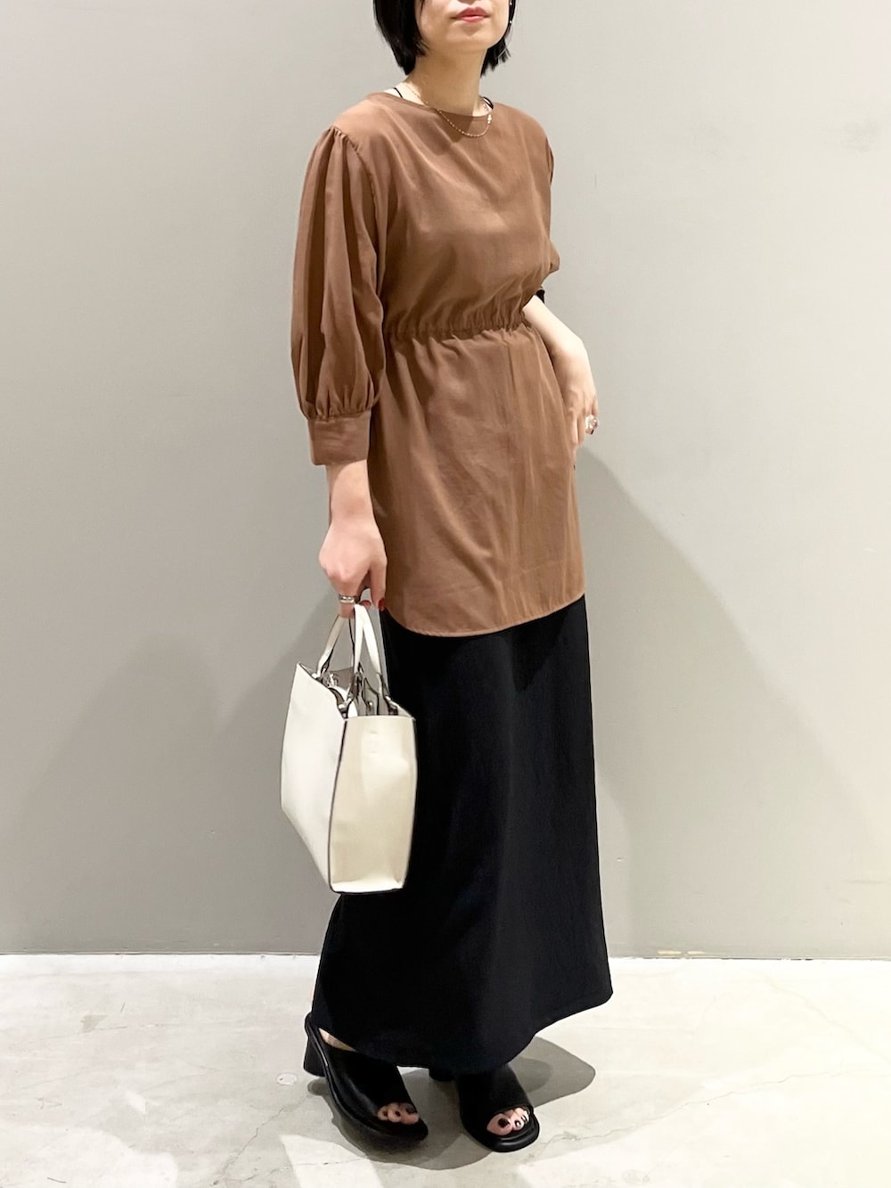 イエロー系のシャツ/ブラウス、ブラック系のスカート、ブラウン系のバッグを着用したレディースの秋コーディネートの4枚目の写真