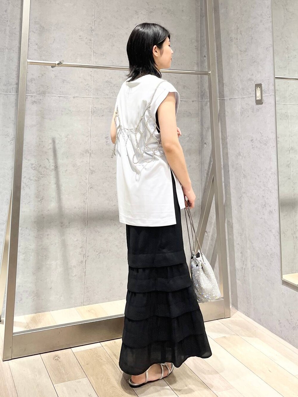 シルバー系のショルダーバッグ、ブルー系のTシャツ/カットソー、シルバー系のサンダルを着用したレディースの夏コーディネートの5枚目の写真