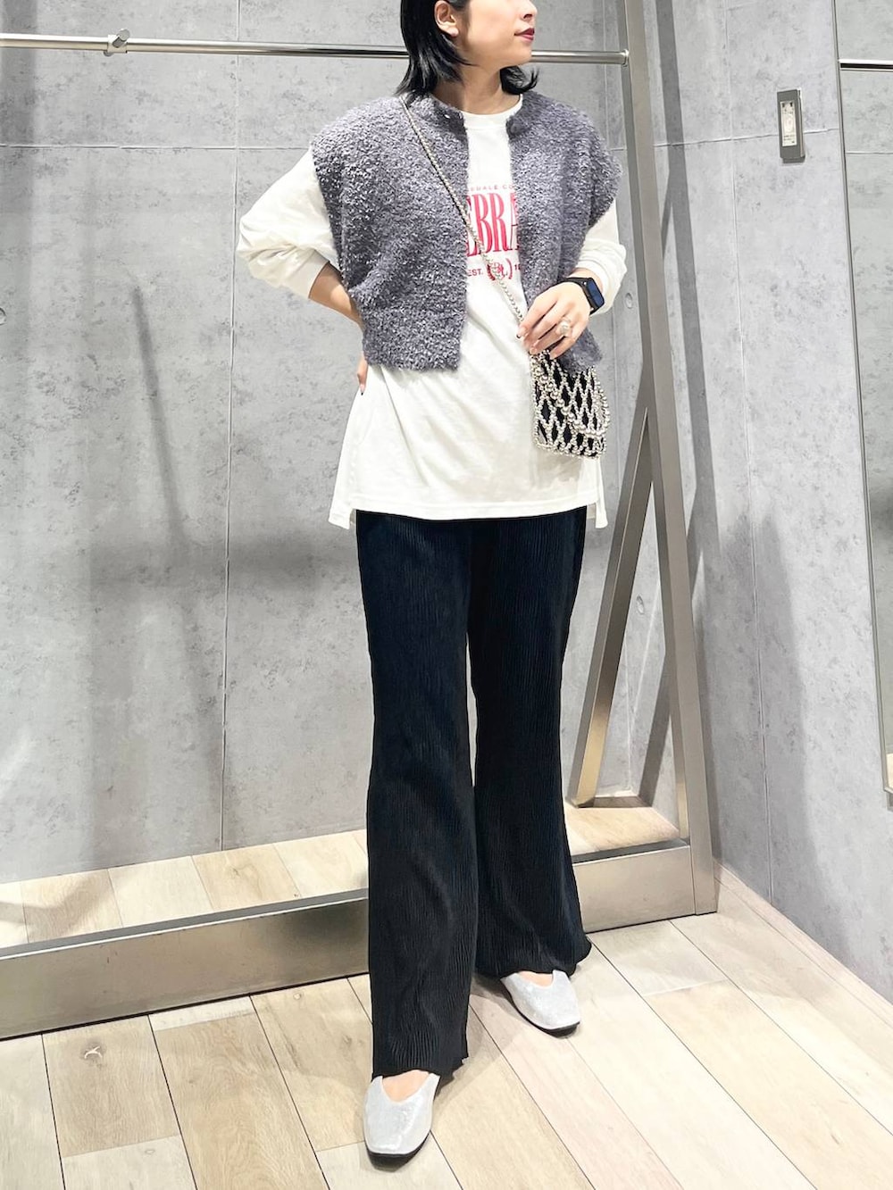 シルバー系のショルダーバッグ、ブラック系のワンピース、シルバー系のパンプスを着用したレディースの秋コーディネートの2枚目の写真