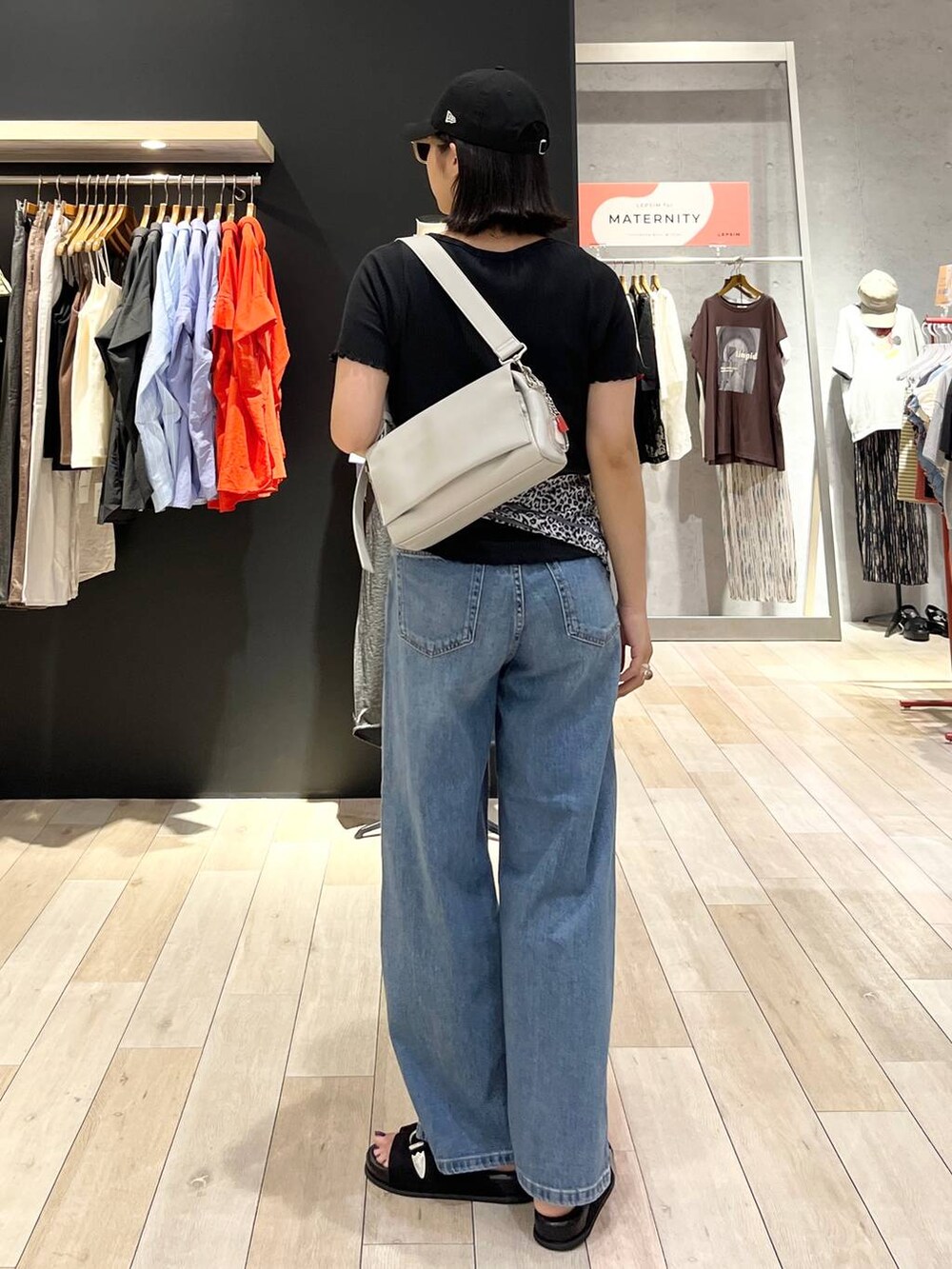 ブラック系のサンダル、ブルー系のデニムパンツ、グレー系のショルダーバッグを着用したレディースの夏コーディネートの4枚目の写真