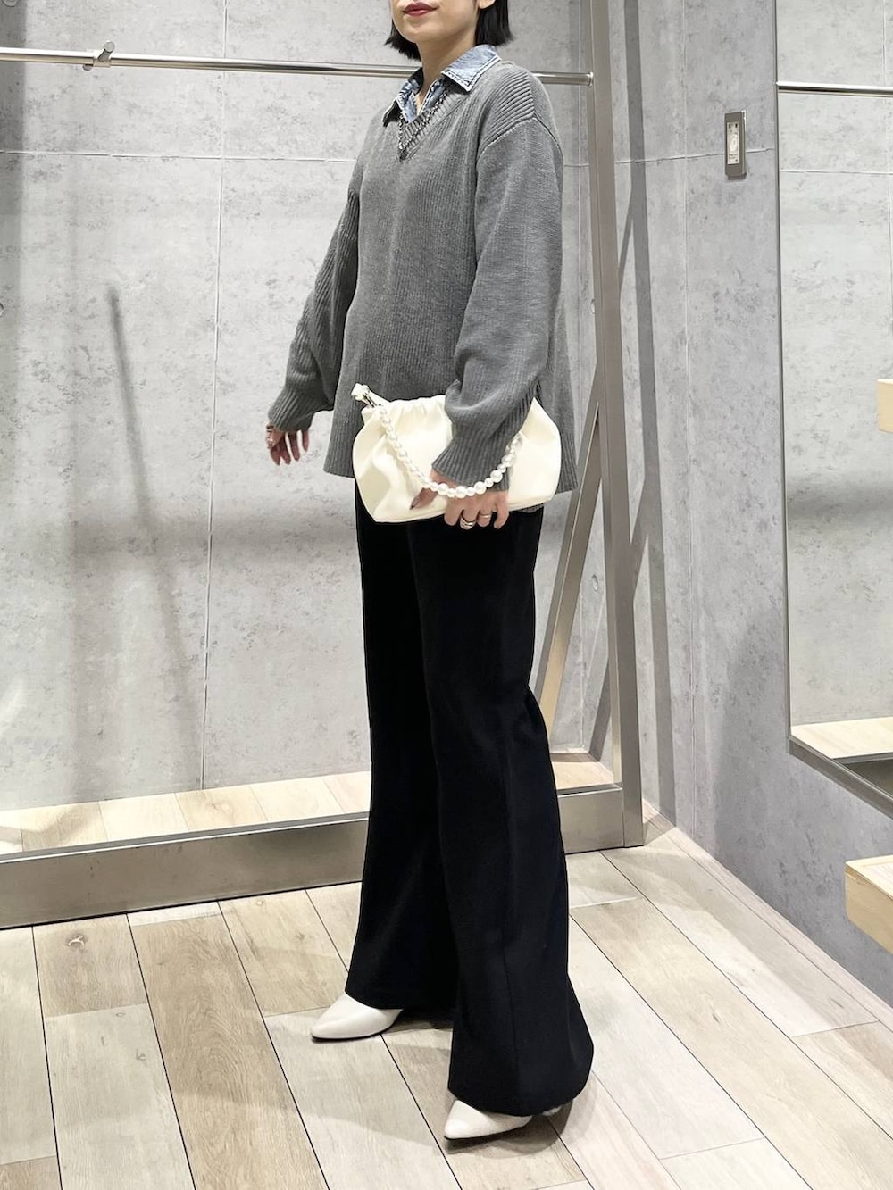 ホワイト系のパンプス、ホワイト系のショルダーバッグ、ブラック系のその他パンツを着用したレディースの冬コーディネートの4枚目の写真