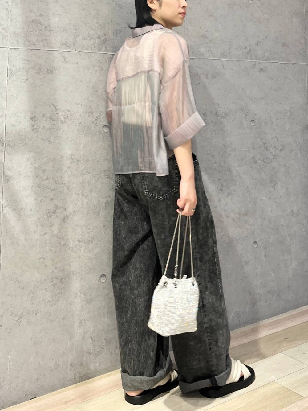 シルバー系のショルダーバッグ、ホワイト系のサンダル、グレー系のデニムパンツを着用したレディースの夏コーディネートの3枚目の写真