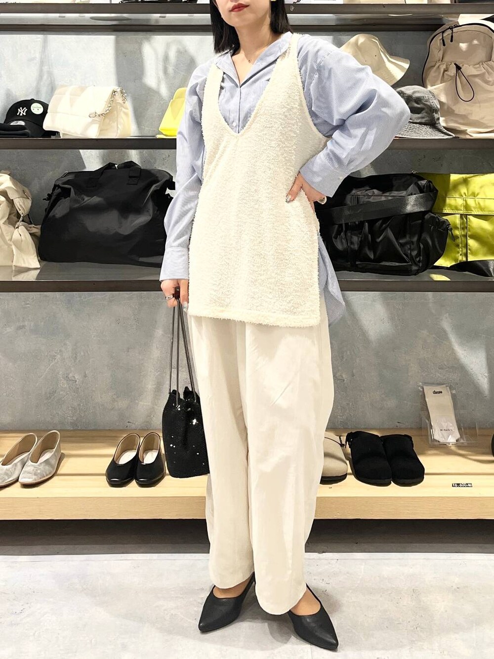 ブラック系のショルダーバッグ、ブラック系のパンプス、ブルー系のシャツ/ブラウスを着用したレディースの春コーディネートの7枚目の写真