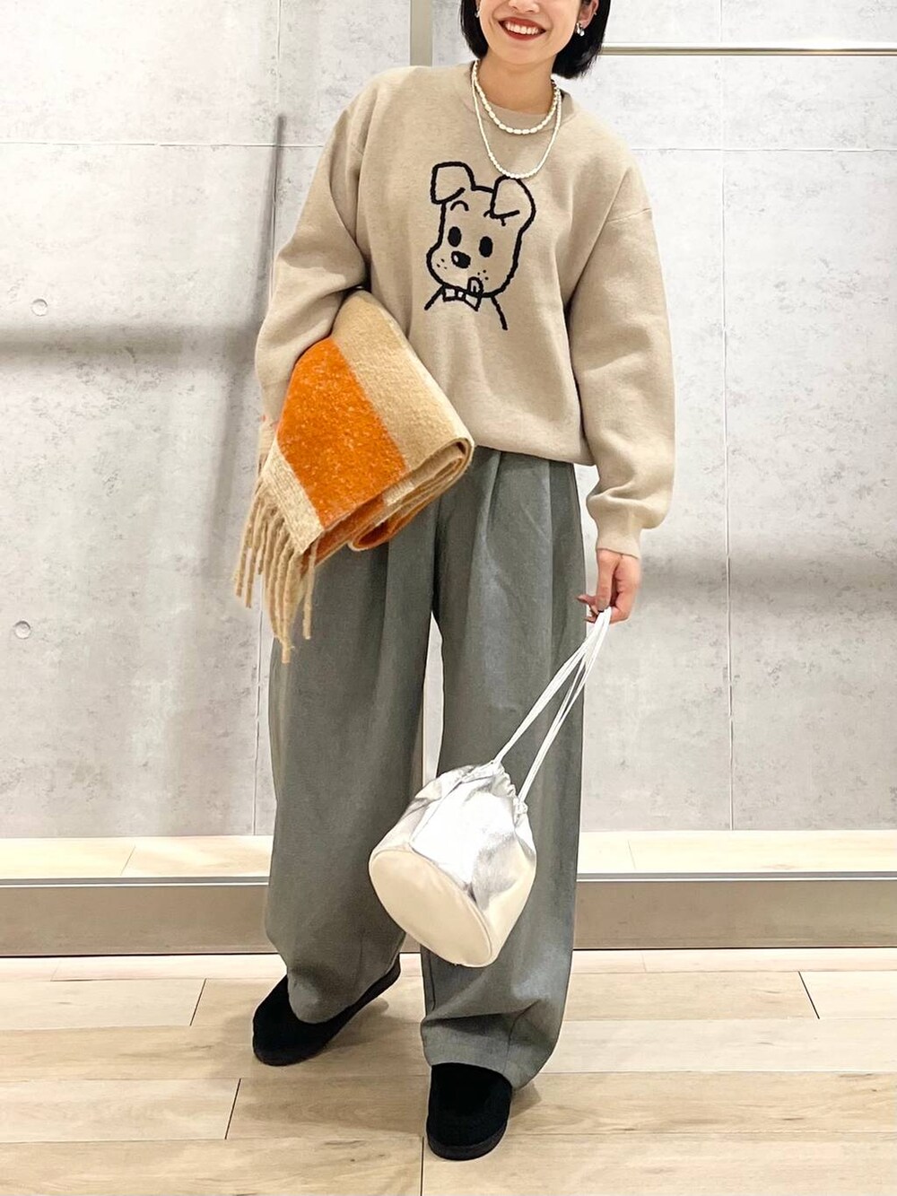 ブラック系のモカシン/デッキシューズ、グレー系のその他パンツ、ベージュ系のニット/セーターを着用したレディースの秋コーディネートの3枚目の写真