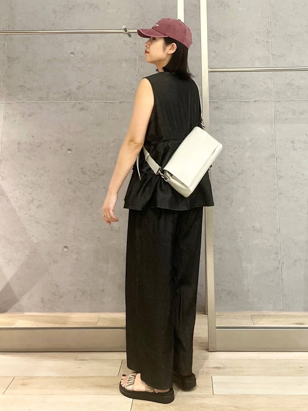 ホワイト系のタンクトップ、ベージュ系のサンダル、ブラック系のつなぎ/オールインワンを着用したレディースの夏コーディネートの4枚目の写真