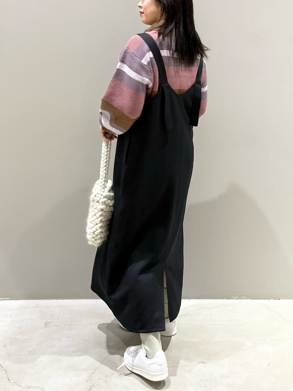 ピンク系のニット/セーター、ホワイト系のバッグ、ホワイト系のスニーカーを着用したレディースの秋コーディネートの2枚目の写真