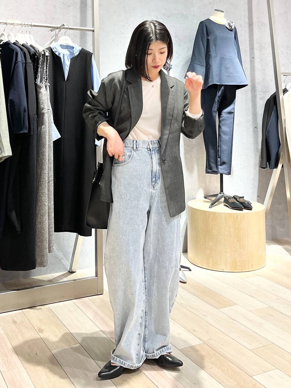 ホワイト系のTシャツ/カットソー、ブルー系のデニムパンツ、ブラック系のショルダーバッグを着用したレディースの冬コーディネートの2枚目の写真