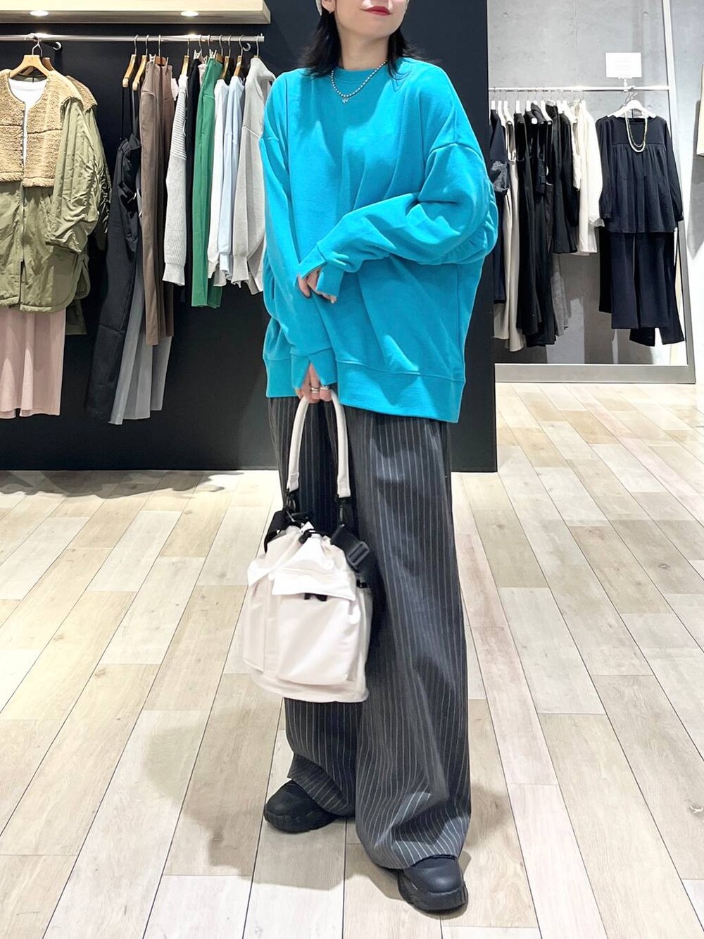 ホワイト系のショルダーバッグ、グレー系のその他パンツ、ブラック系のスニーカーを着用したレディースの冬コーディネートの7枚目の写真