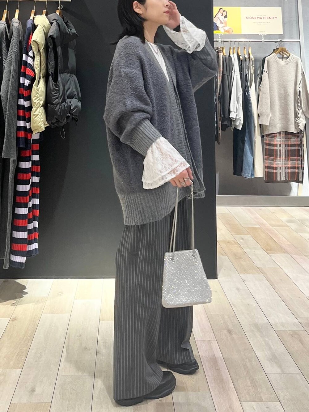 シルバー系のショルダーバッグ、ブラック系のブーツ、ホワイト系のTシャツ/カットソーを着用したレディースの秋コーディネートの4枚目の写真