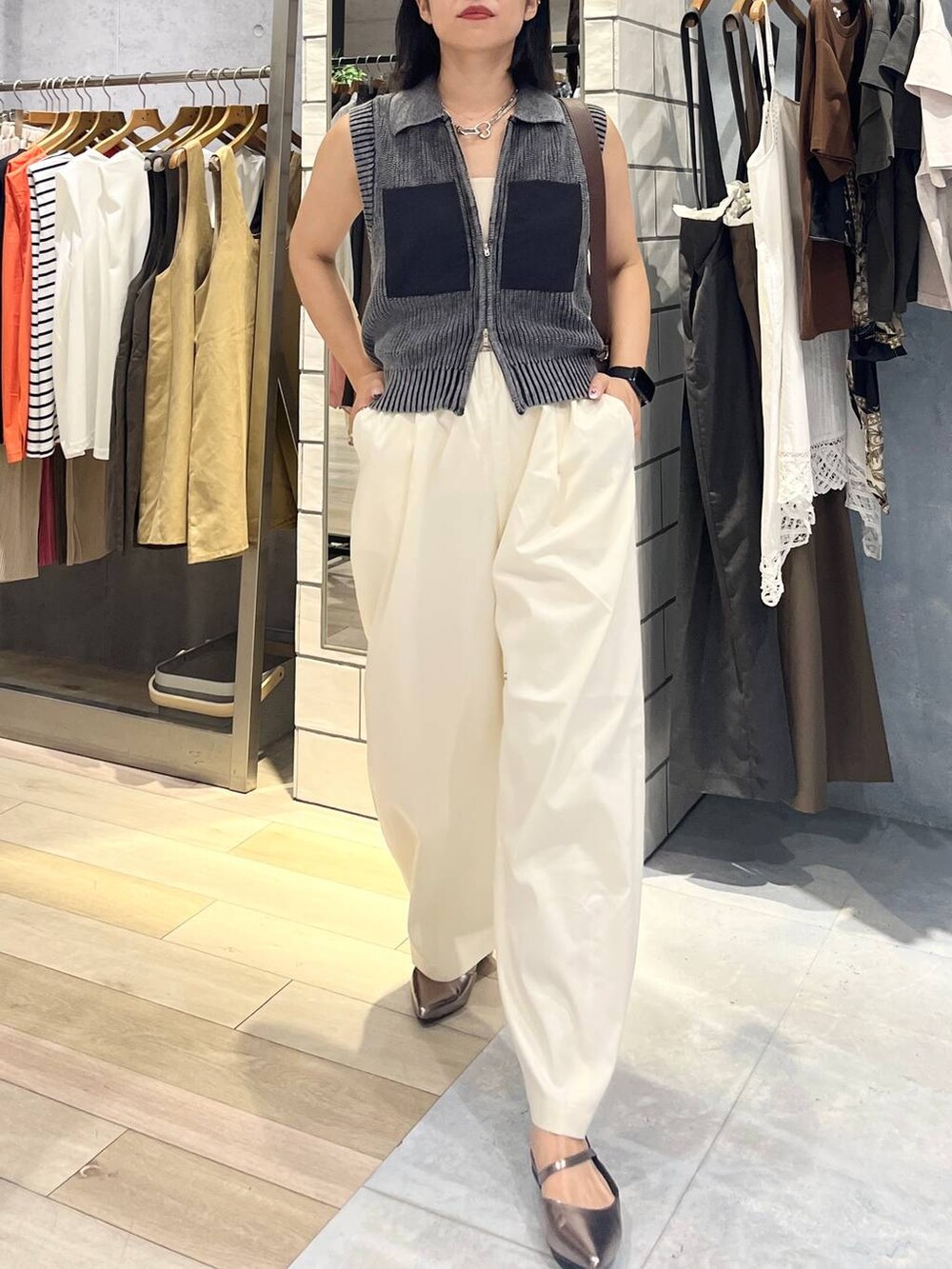 ブラウン系のショルダーバッグ、ホワイト系のタンクトップ、シルバー系のキーホルダーを着用したレディースの夏コーディネートの3枚目の写真