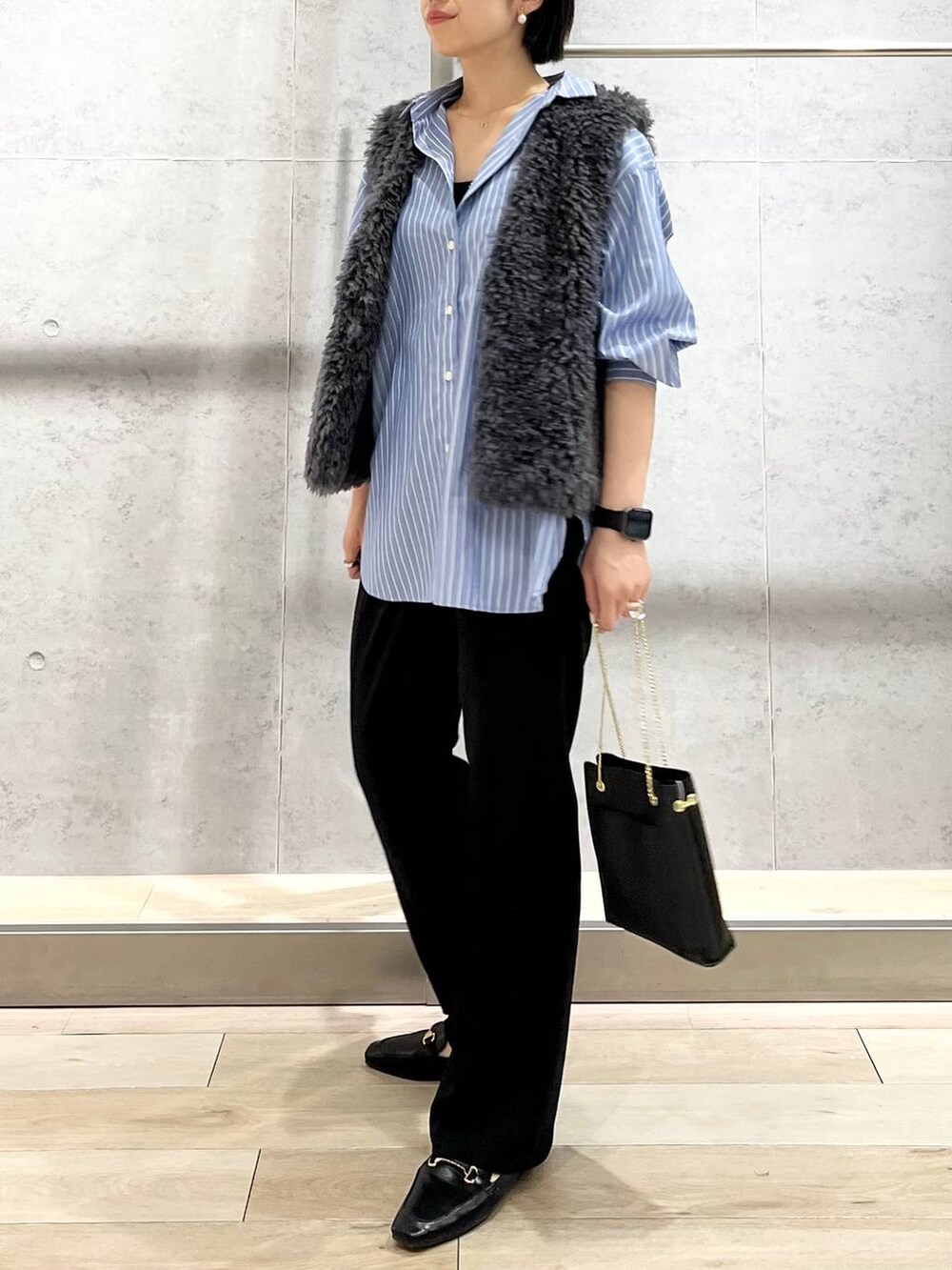 グレー系のベスト、ブラック系のその他パンツ、ブラック系のローファーを着用したレディースの秋コーディネートの9枚目の写真