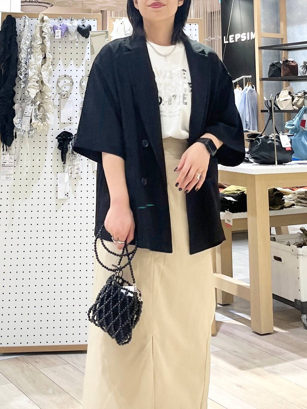 ブラック系のテーラードジャケット、ブラック系のショルダーバッグ、ホワイト系のTシャツ/カットソーを着用したレディースの夏コーディネートの7枚目の写真