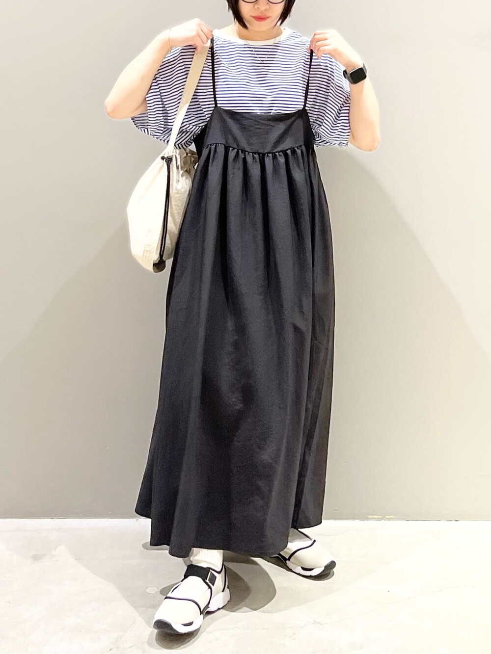 ブラック系のワンピース、ブルー系のTシャツ/カットソー、ホワイト系のショルダーバッグを着用したレディースの秋コーディネートの6枚目の写真