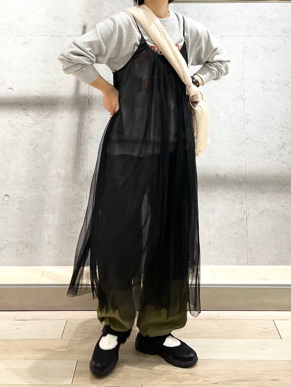 グレー系のスウェット、ブラック系のスニーカー、グリーン系のカーゴパンツを着用したレディースの秋コーディネートの7枚目の写真