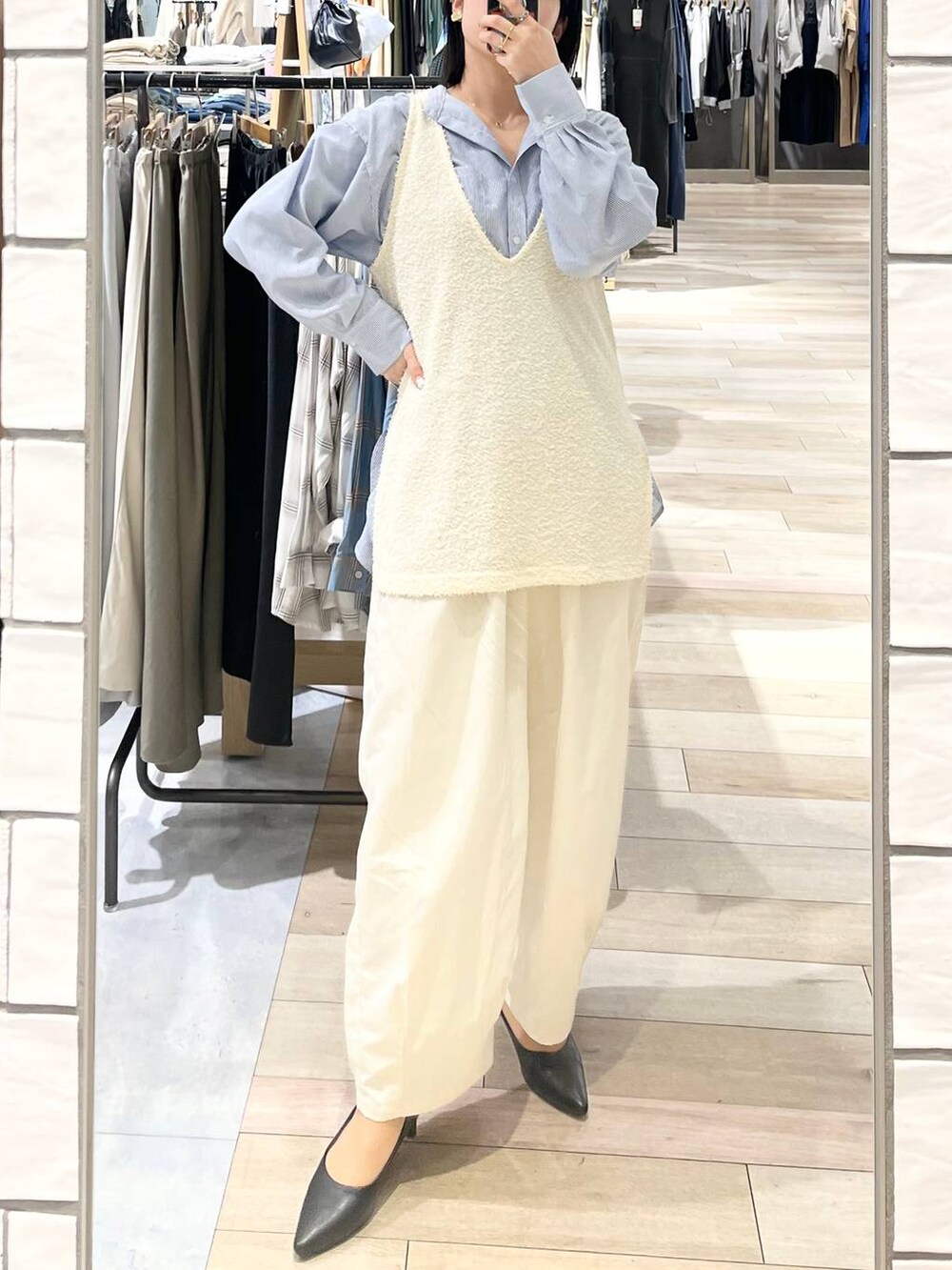 ブラック系のショルダーバッグ、ブラック系のパンプス、ブルー系のシャツ/ブラウスを着用したレディースの春コーディネートの9枚目の写真