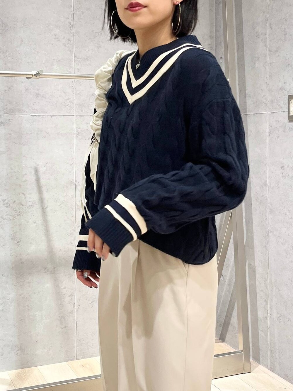 ブルー系のニット/セーター、ホワイト系のショルダーバッグ、ブラック系のパンプスを着用したレディースの冬コーディネートの5枚目の写真