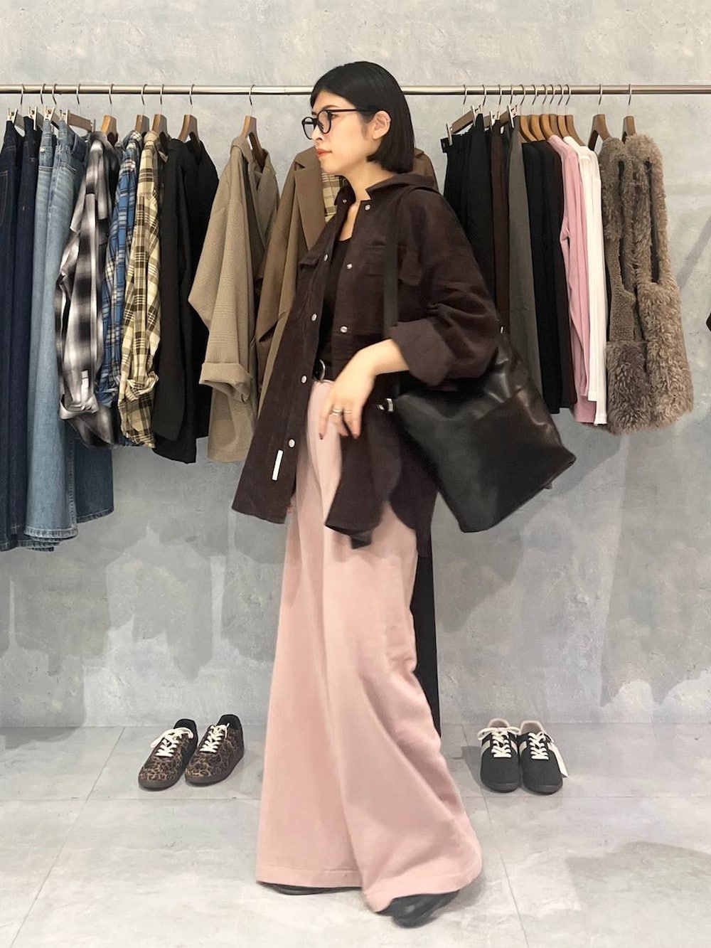 ピンク系のスウェットパンツ、ブラック系のショルダーバッグ、ブラウン系のシャツ/ブラウスを着用したレディースの秋コーディネートの3枚目の写真