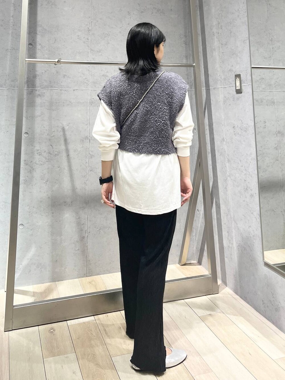 シルバー系のショルダーバッグ、ブラック系のワンピース、シルバー系のパンプスを着用したレディースの秋コーディネートの3枚目の写真