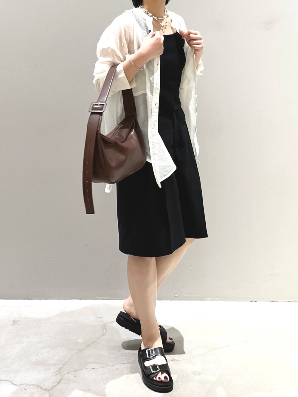 ブラウン系のショルダーバッグ、ブラック系のサンダル、ブラック系のその他パンツを着用したレディースの夏コーディネートの4枚目の写真