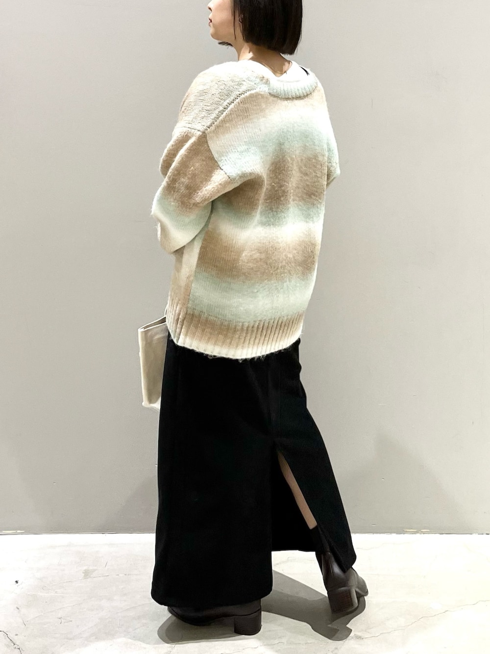 ブラック系のワンピース、グリーン系のカーディガン/ボレロ、ホワイト系のTシャツ/カットソーを着用したレディースの冬コーディネートの4枚目の写真