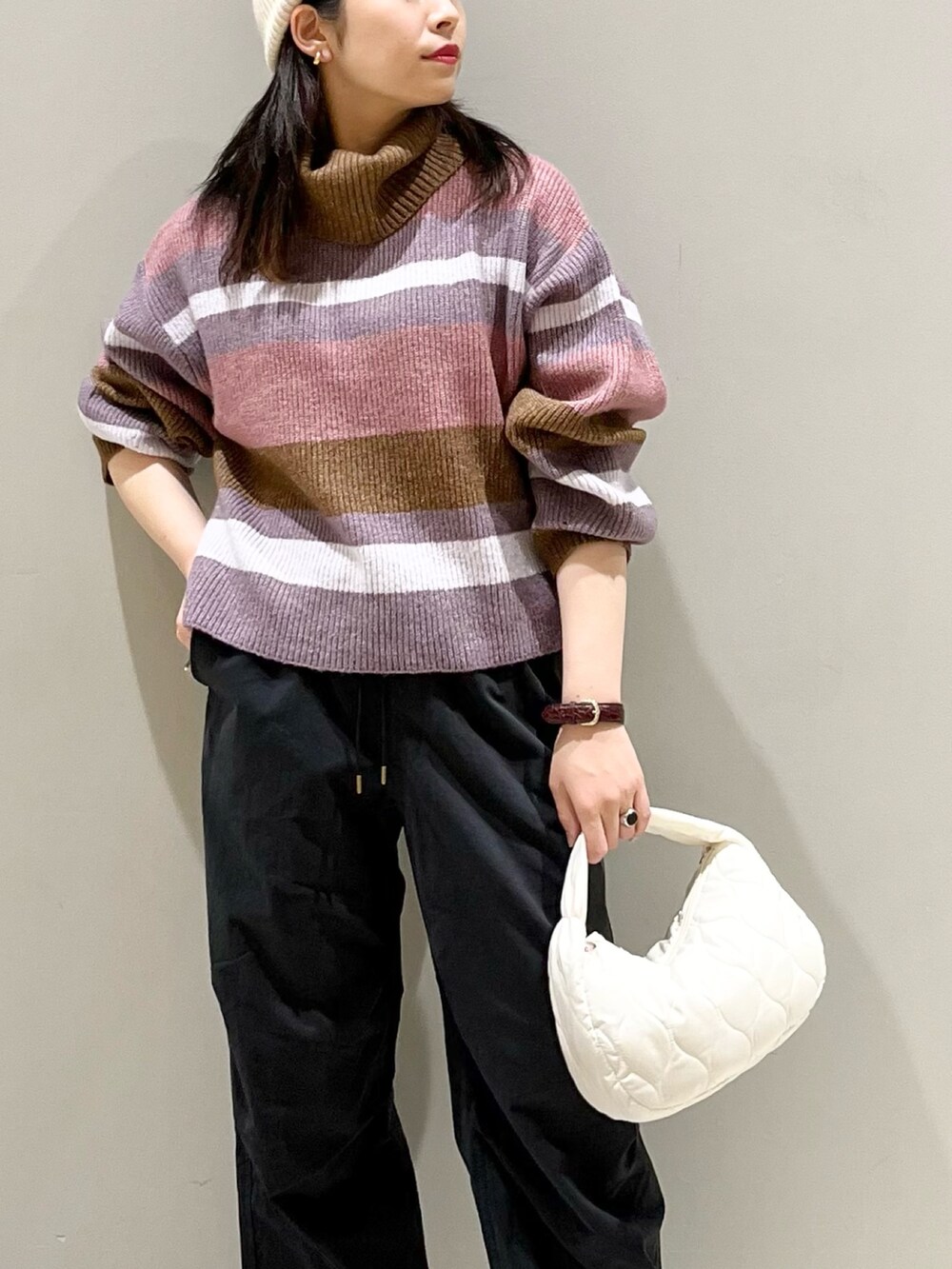 ピンク系のニット/セーター、ブラック系のカーゴパンツ、ブラック系のブーツを着用したレディースの秋コーディネートの5枚目の写真