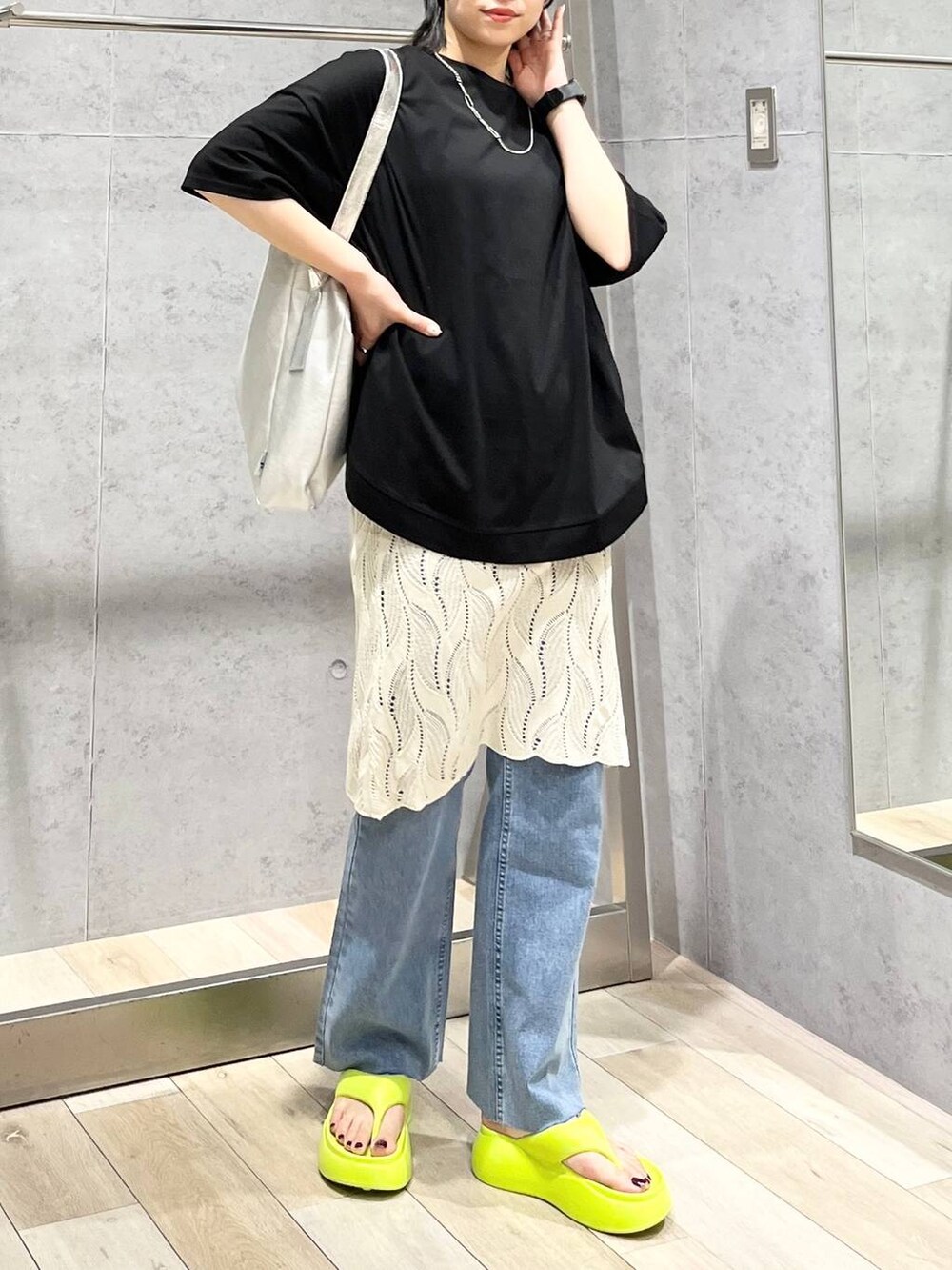 イエロー系のサンダル、グレー系のショルダーバッグ、ブルー系のデニムパンツを着用したレディースの春コーディネートの7枚目の写真
