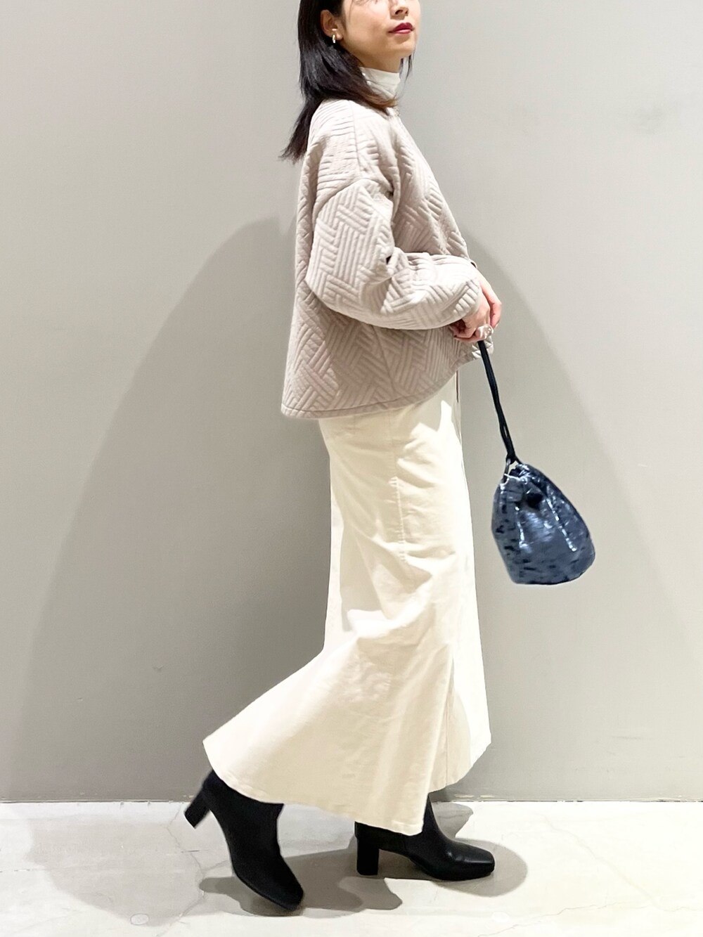 ベージュ系のTシャツ/カットソー、グリーン系のトップス、ブルー系のショルダーバッグを着用したレディースの冬コーディネートの3枚目の写真