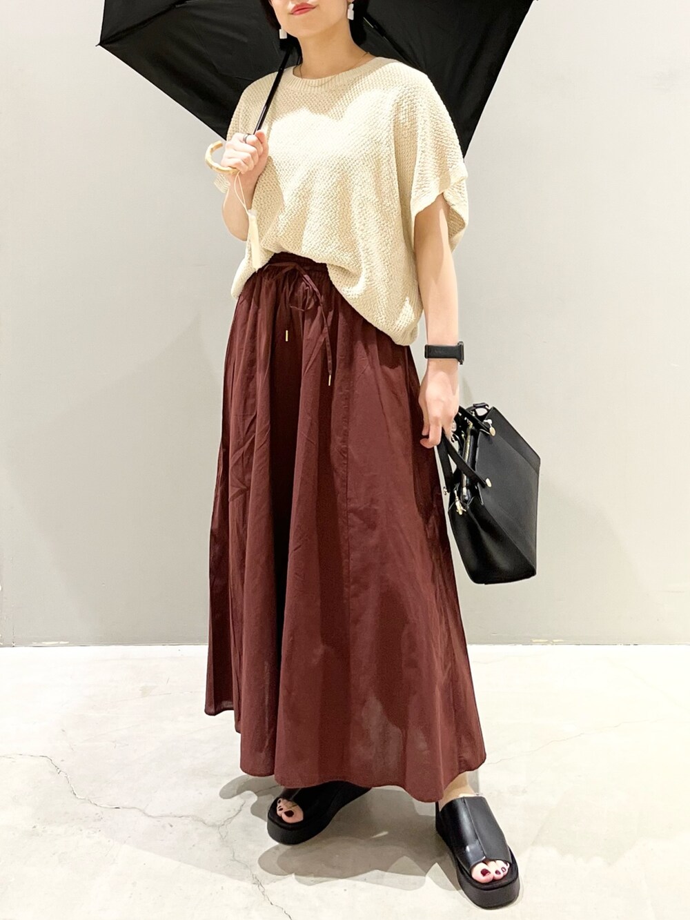 ブラック系のサンダル、ブラウン系のその他パンツ、ブラック系のショルダーバッグを着用したレディースの夏コーディネートの4枚目の写真