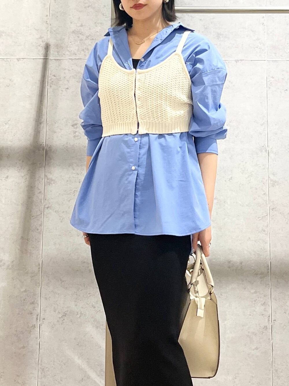 ブルー系のシャツ/ブラウス、ブラック系のスカート、ホワイト系のショルダーバッグを着用したレディースの冬コーディネートの7枚目の写真