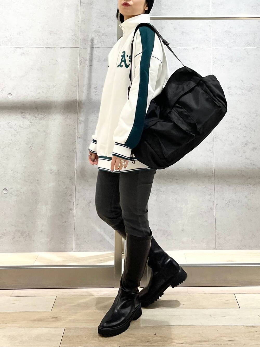 ホワイト系のTシャツ/カットソー、ブラック系のブーツ、グレー系のデニムパンツを着用したレディースの冬コーディネートの7枚目の写真