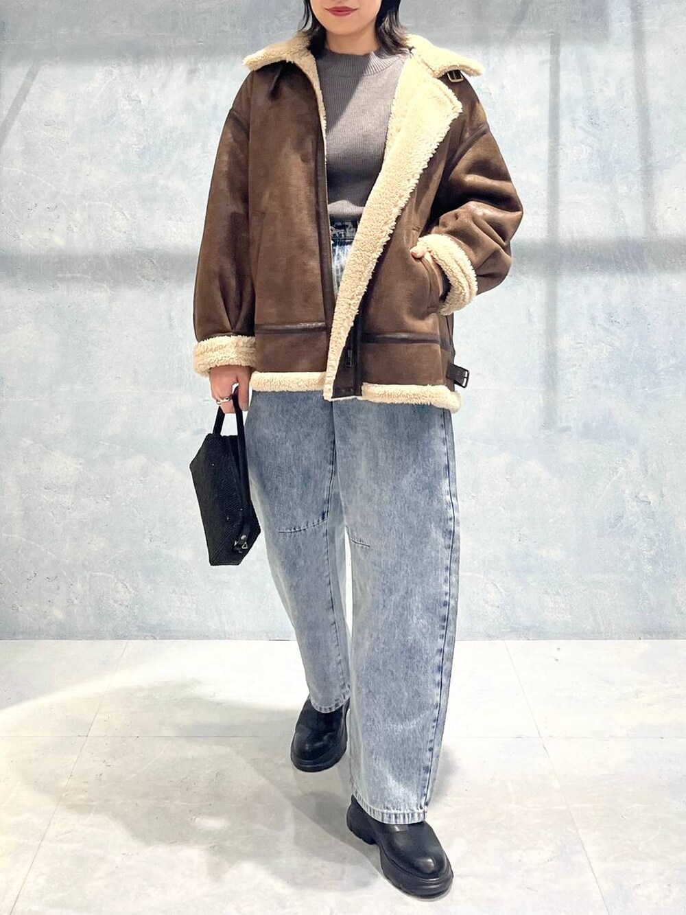 ブラウン系のその他アウター、ブラック系のブーツ、グレー系のニット/セーターを着用したレディースの秋コーディネートの5枚目の写真