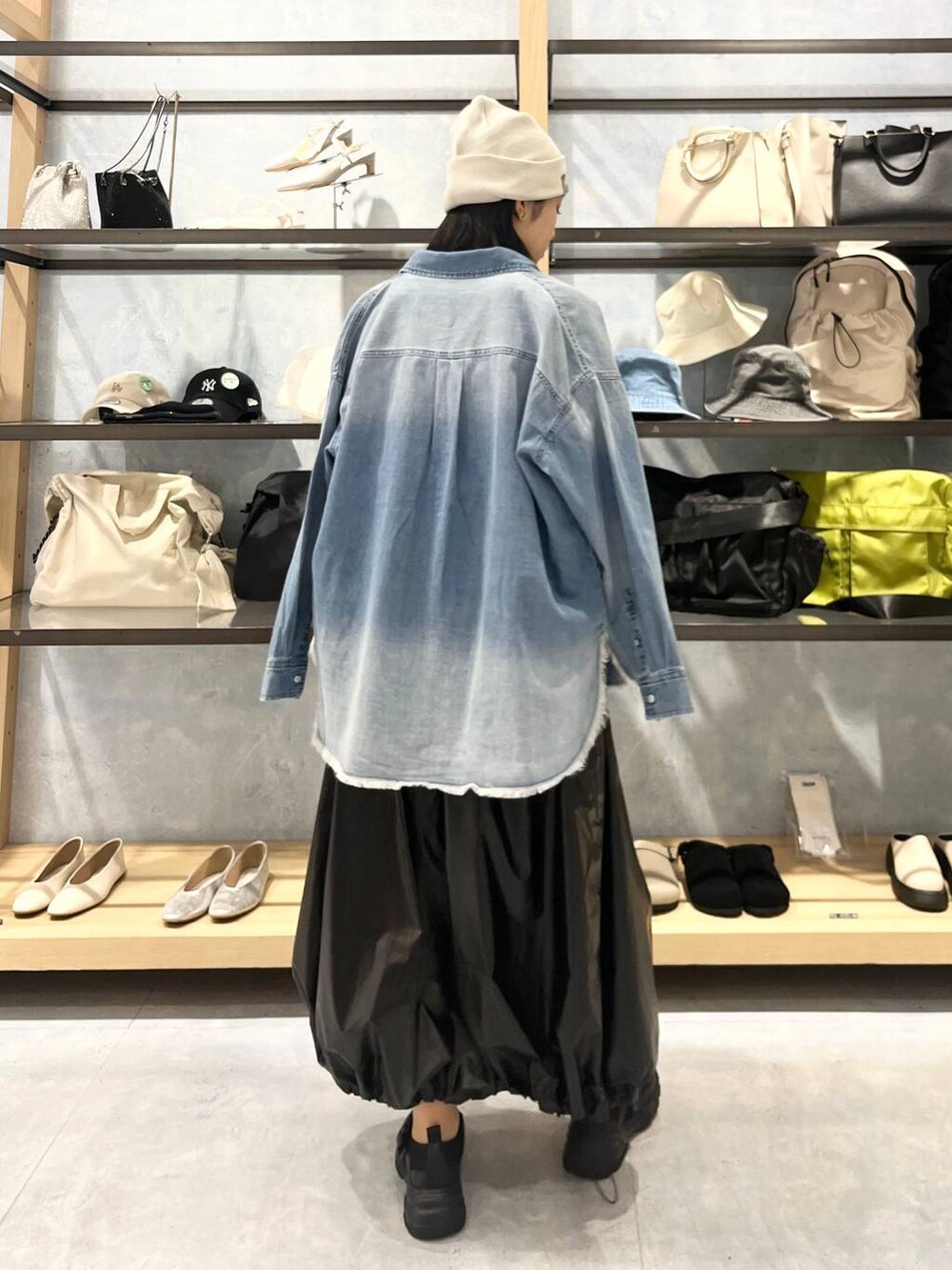 ブラック系のショルダーバッグ、ブラック系のTシャツ/カットソー、ブラック系のスニーカーを着用したレディースの春コーディネートの3枚目の写真