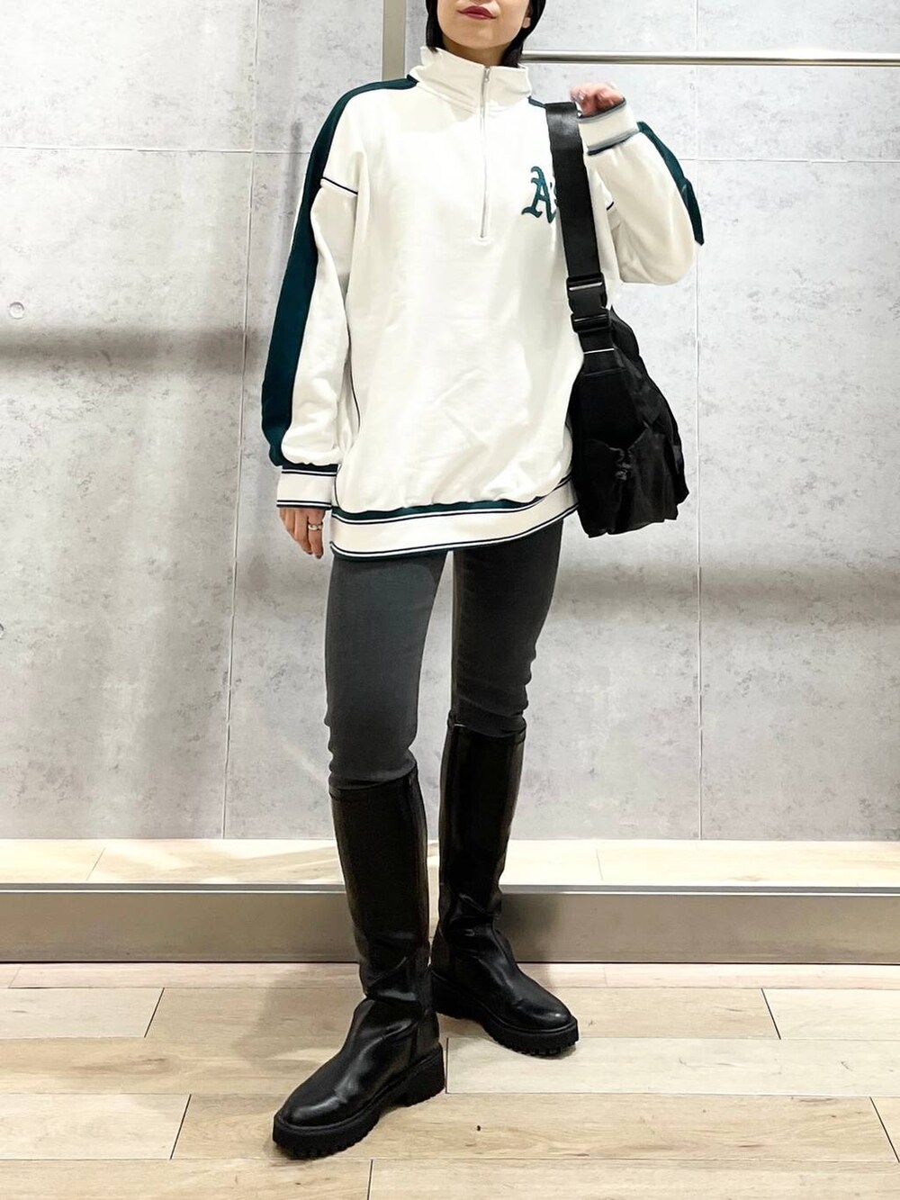 ホワイト系のTシャツ/カットソー、ブラック系のブーツ、グレー系のデニムパンツを着用したレディースの冬コーディネートの4枚目の写真