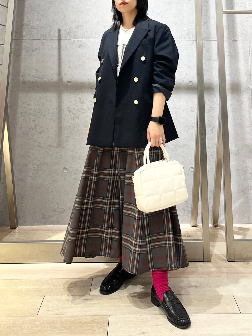 ブルー系のテーラードジャケット、ホワイト系のボストンバッグ、ブラック系のローファーを着用したレディースの秋コーディネートの2枚目の写真