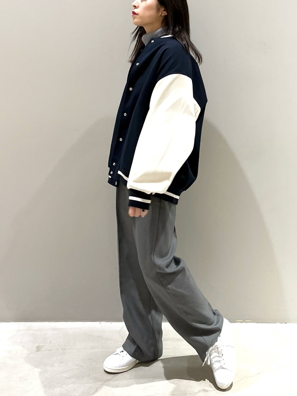 ホワイト系のスニーカー、グレー系のパンツ、ブルー系のジャケット/アウターを着用したレディースの秋コーディネートの2枚目の写真