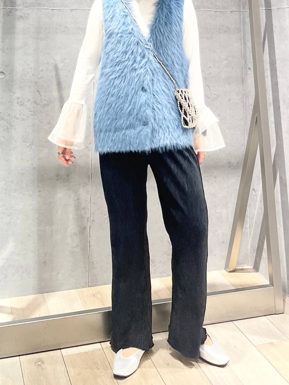 シルバー系のパンプス、ホワイト系のTシャツ/カットソー、ブルー系のベストを着用したレディースの秋コーディネートの5枚目の写真