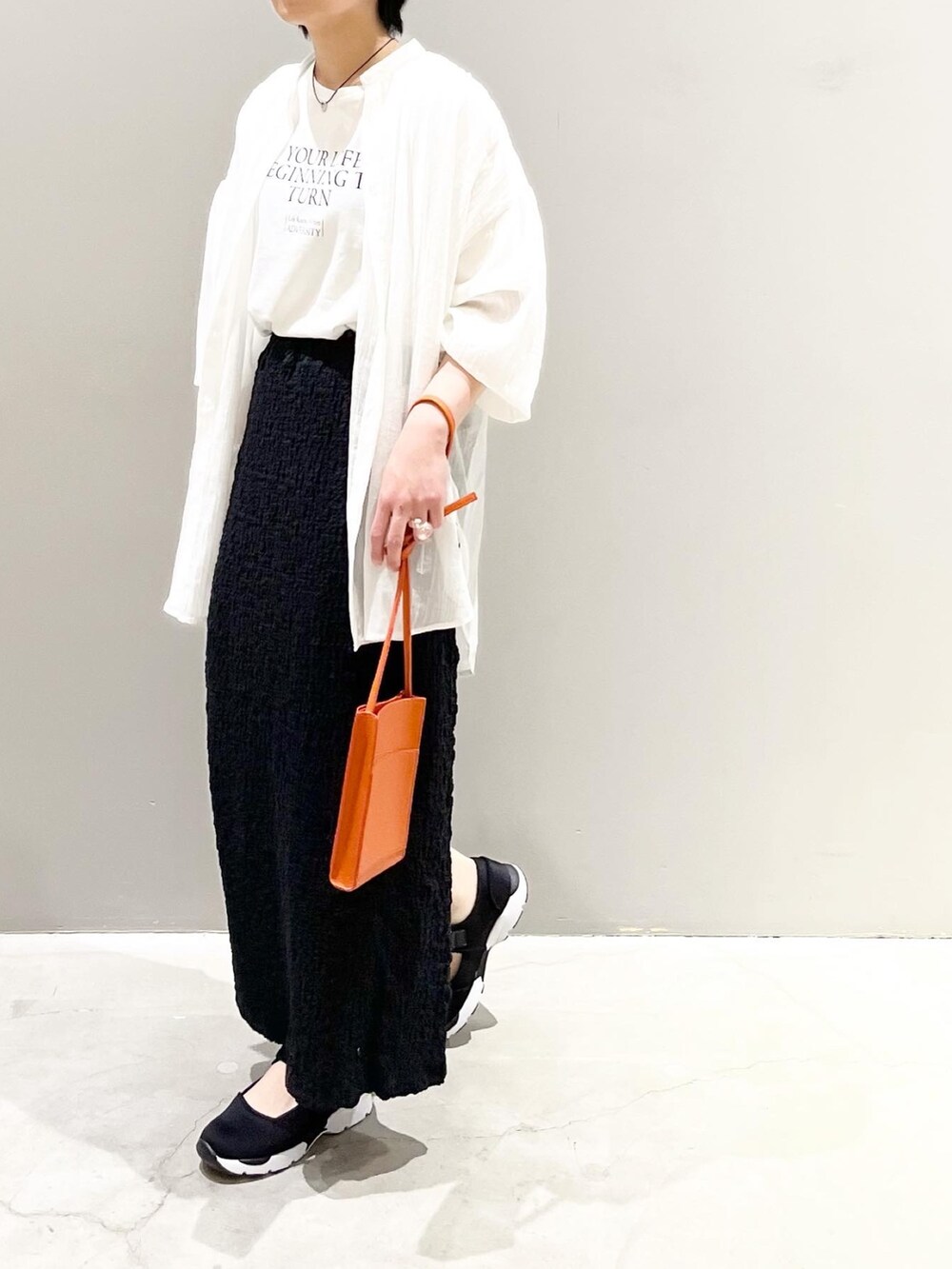 ホワイト系のTシャツ/カットソー、ホワイト系のシャツ/ブラウス、ブラック系のスカートを着用したレディースの春コーディネートの5枚目の写真