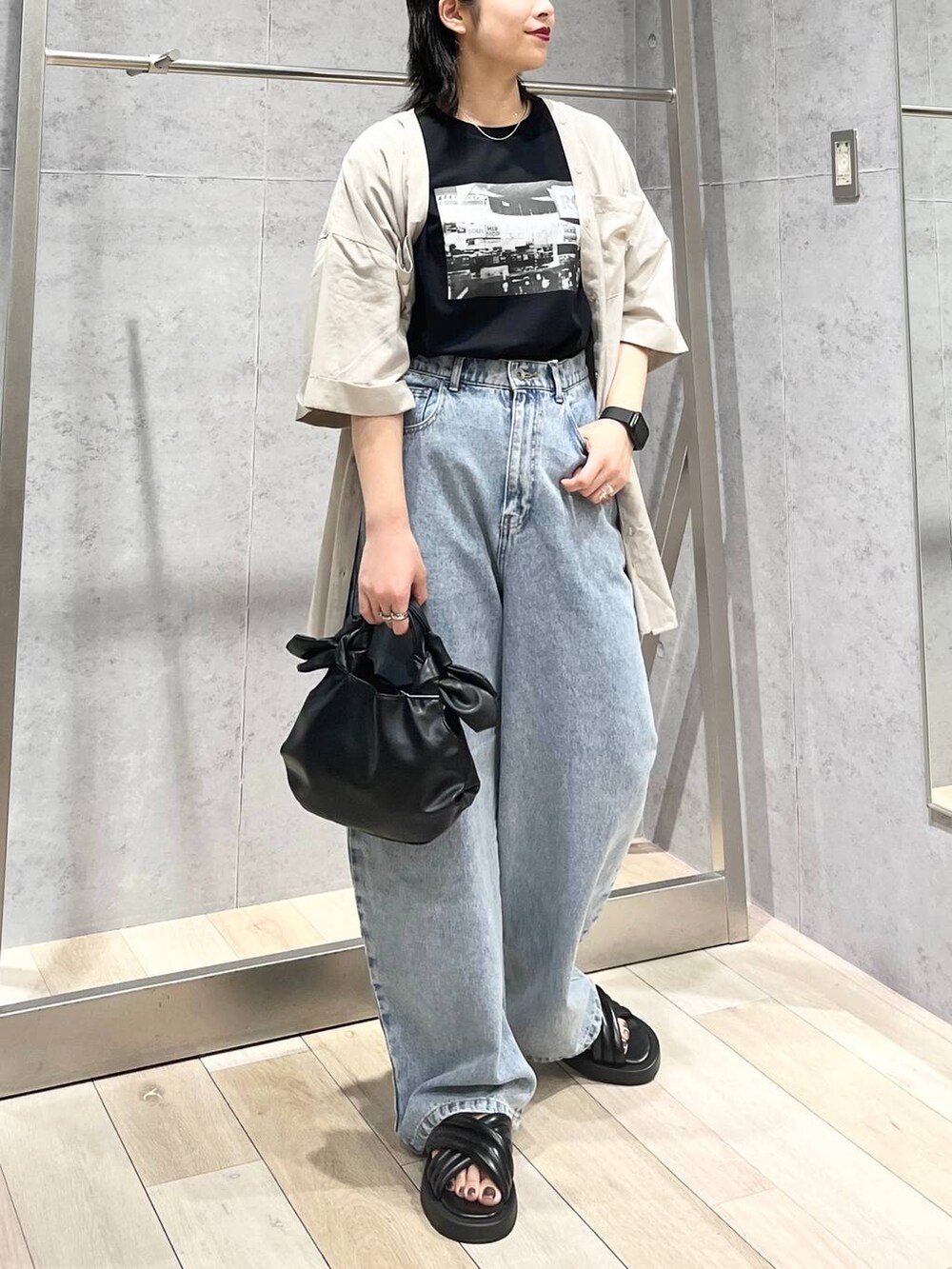 ブラック系のTシャツ/カットソー、ブラック系のサンダル、ブルー系のデニムパンツを着用したレディースの夏コーディネートの5枚目の写真