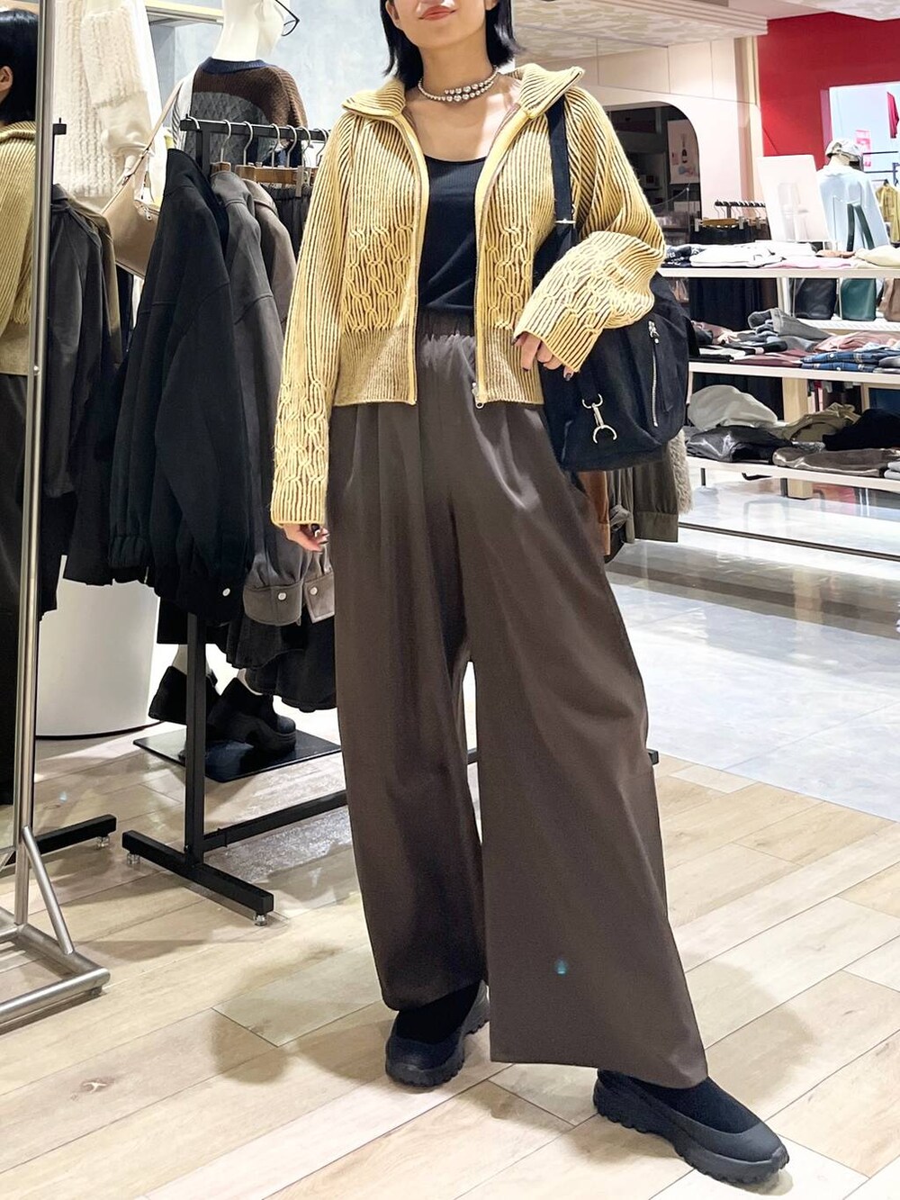 ブラウン系のその他パンツ、ブラック系のその他シューズ、ブラック系のショルダーバッグを着用したレディースの冬コーディネートの5枚目の写真