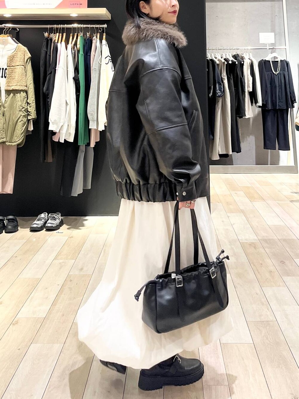 ブラック系のTシャツ/カットソー、ブラック系のブーツ、ブラック系のショルダーバッグを着用したレディースの冬コーディネートの4枚目の写真