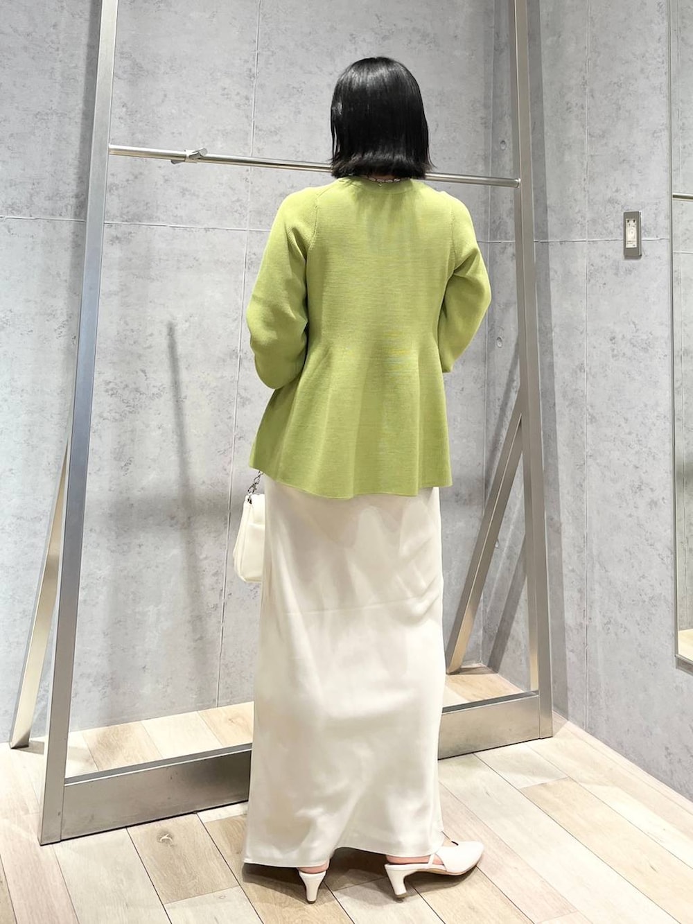 ホワイト系のショルダーバッグ、グリーン系のニット/セーター、ホワイト系のスカートを着用したレディースの春コーディネートの3枚目の写真