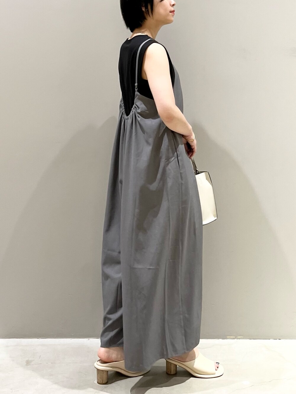 ホワイト系のショルダーバッグ、グレー系のその他パンツ、ホワイト系のサンダルを着用したレディースの夏コーディネートの4枚目の写真