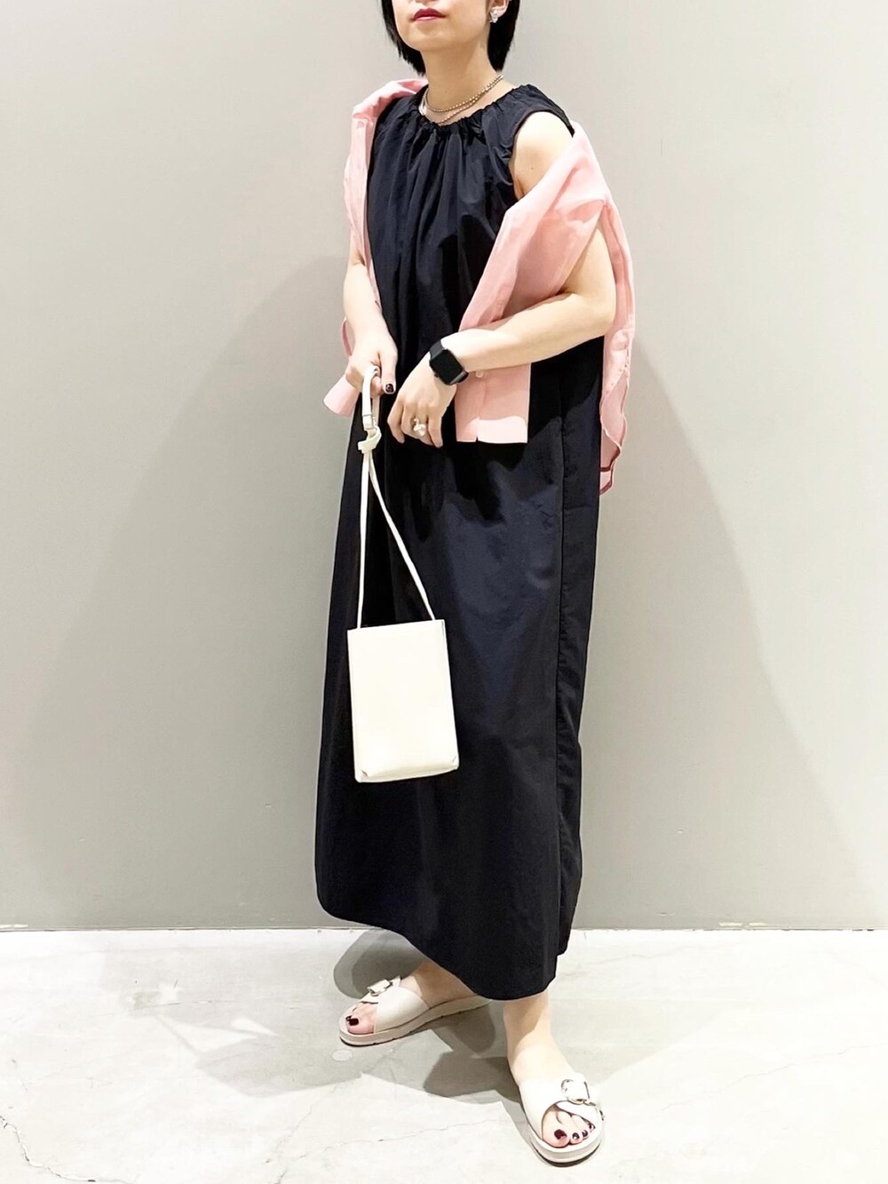 オレンジ系のバッグ、ピンク系のシャツ/ブラウス、ブラック系のワンピースを着用したレディースの夏コーディネートの4枚目の写真