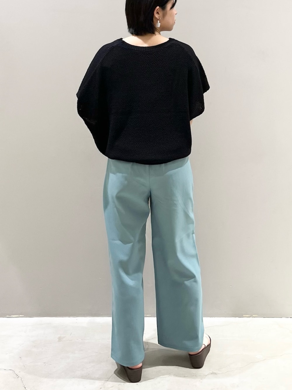 ブラック系のその他トップス、グリーン系のスラックス、ホワイト系のサンダルを着用したレディースの春コーディネートの2枚目の写真