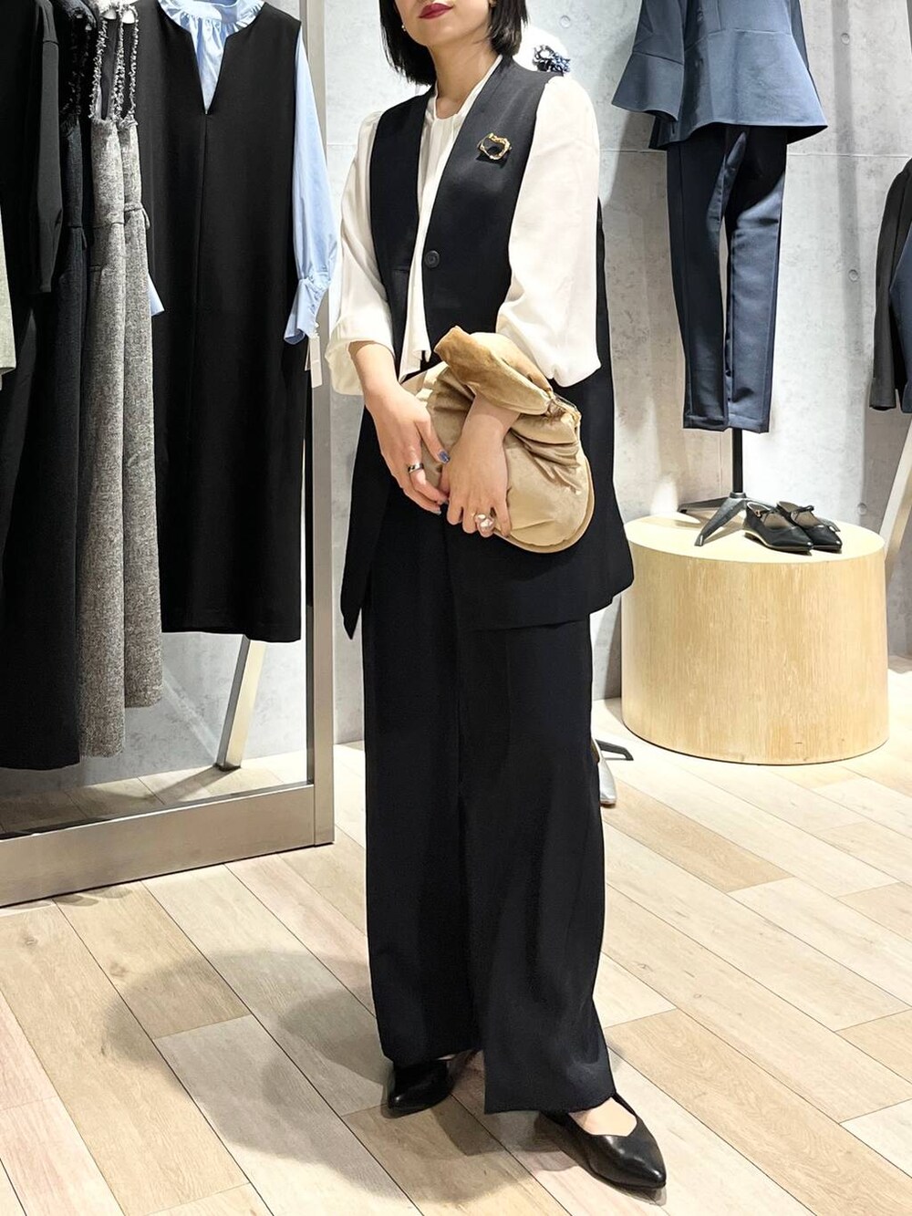 ベージュ系のハンドバッグ、ホワイト系のシャツ/ブラウス、ブラック系のパンプスを着用したレディースの冬コーディネートの5枚目の写真