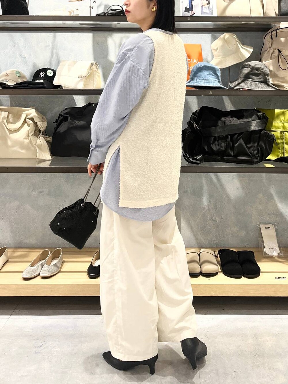 ブラック系のショルダーバッグ、ブラック系のパンプス、ブルー系のシャツ/ブラウスを着用したレディースの春コーディネートの4枚目の写真