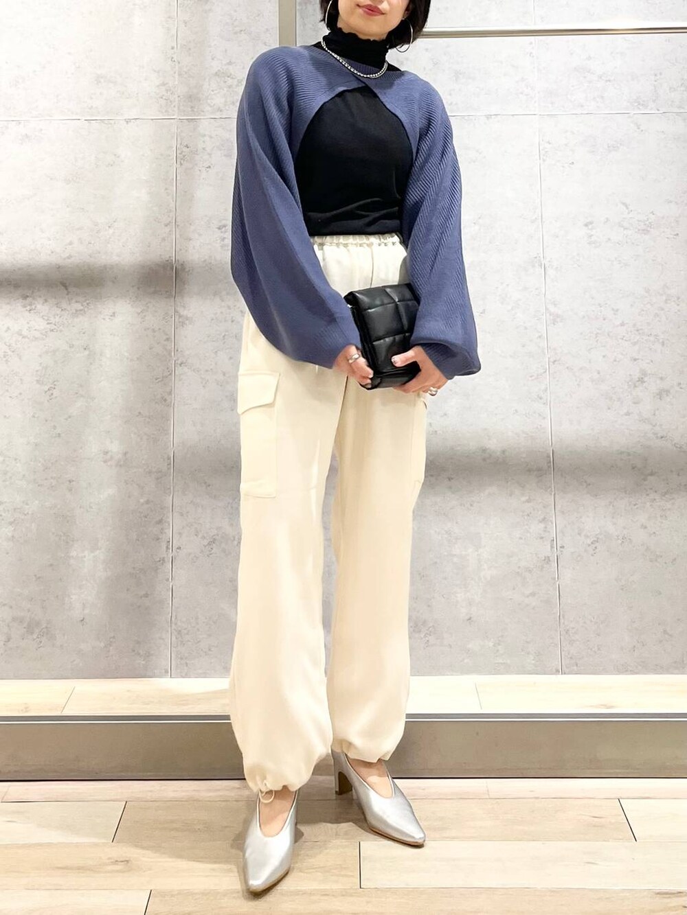 ブルー系のワンピース、ブラック系のTシャツ/カットソー、ブラック系のショルダーバッグを着用したレディースの秋コーディネートの5枚目の写真