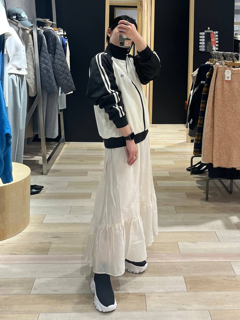 ホワイト系のスカート、ブラック系のブーツ、ブルー系のTシャツ/カットソーを着用したレディースの冬コーディネートの9枚目の写真